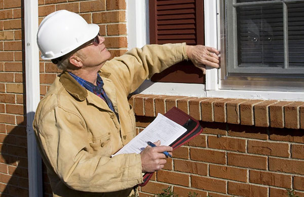 Home inspector reviewing exterior window